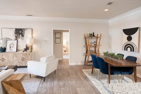 a living and dining room area with a wooden table and blue chairs